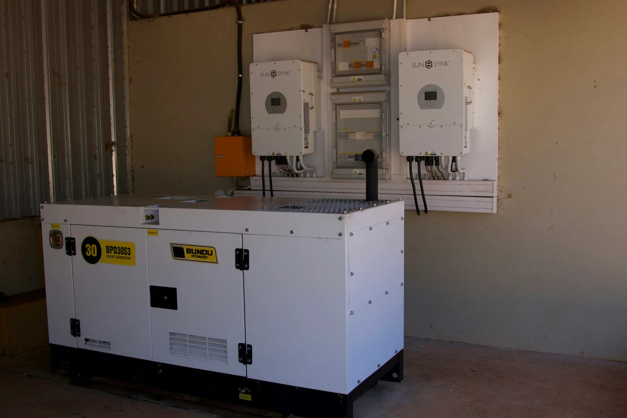 Large industrial generating set installed beside power distribution equipment